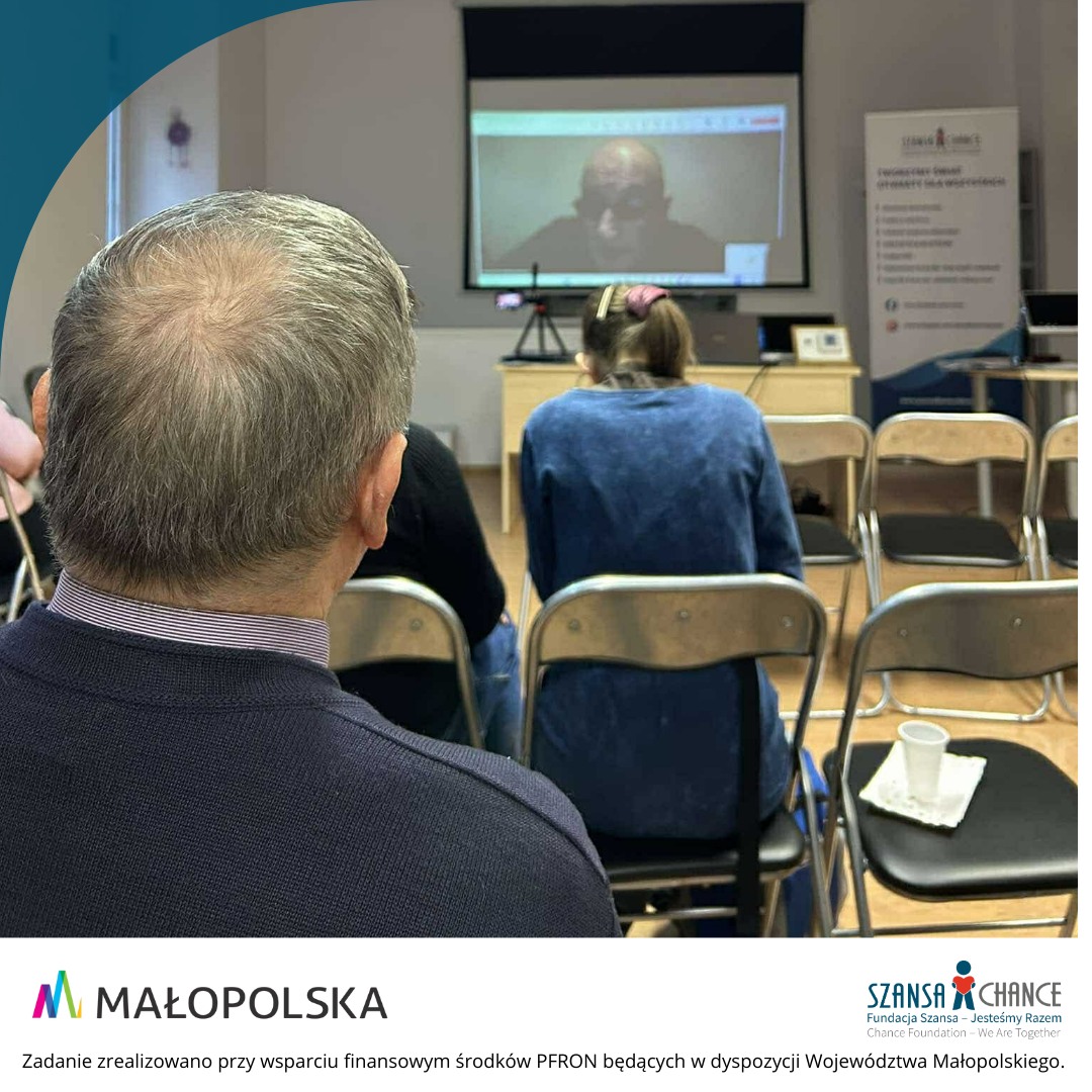 Starszy pan siedzący na konferencji.